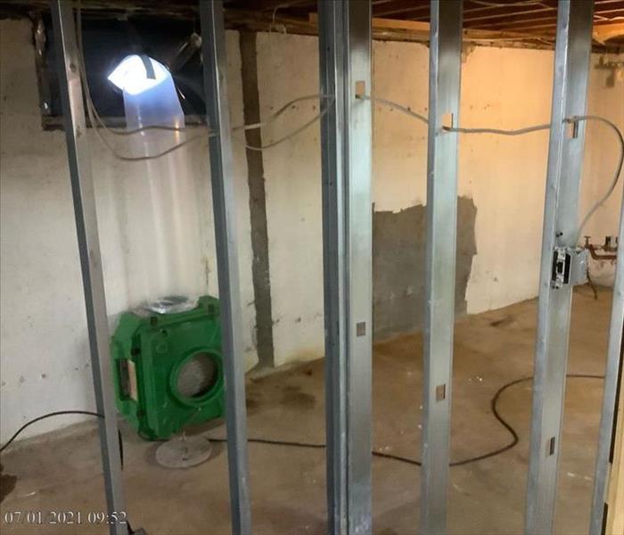 Basement with studs exposed and SERVPRO drying equipment