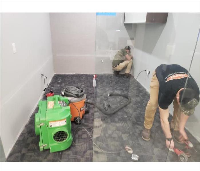 SERVPRO techs working on commercial water damage in shower