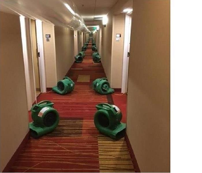 rows of air movers in hotel corridor, overhead ducting