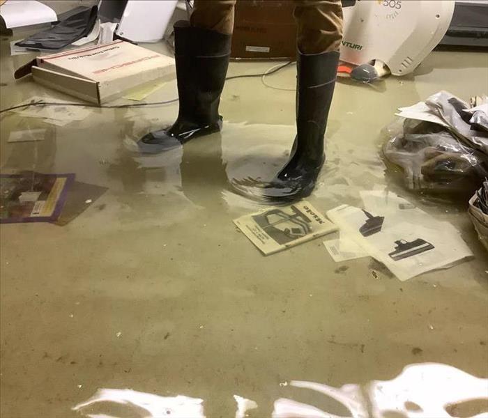 Person in boots standing in water in a basement