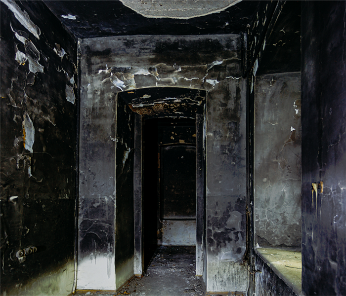 a fire damaged hallway with soot covering the walls