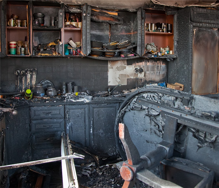 soot covering a fire damaged kitchen and furniture within it